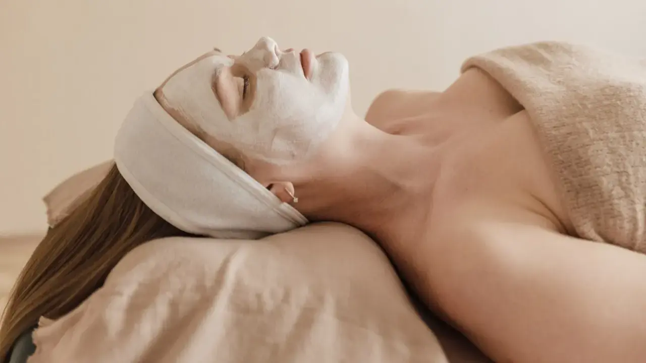 Visage couvert d'un masque blanc, une femme se détend. Attention à l'allantoïne, son danger potentiel pour la peau.