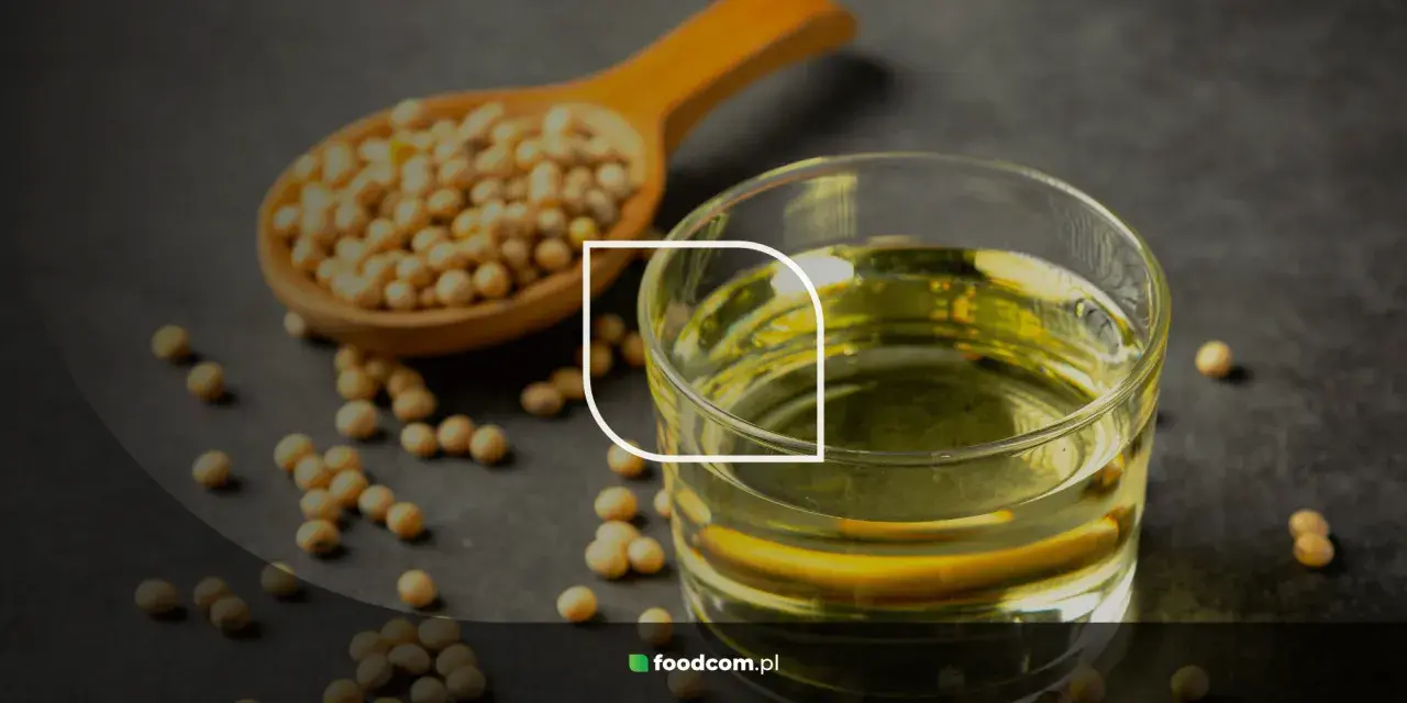 Grains de soja dans une cuillère en bois et un verre d'huile de soja, illustrant les huile de soja bienfaits pour la santé.