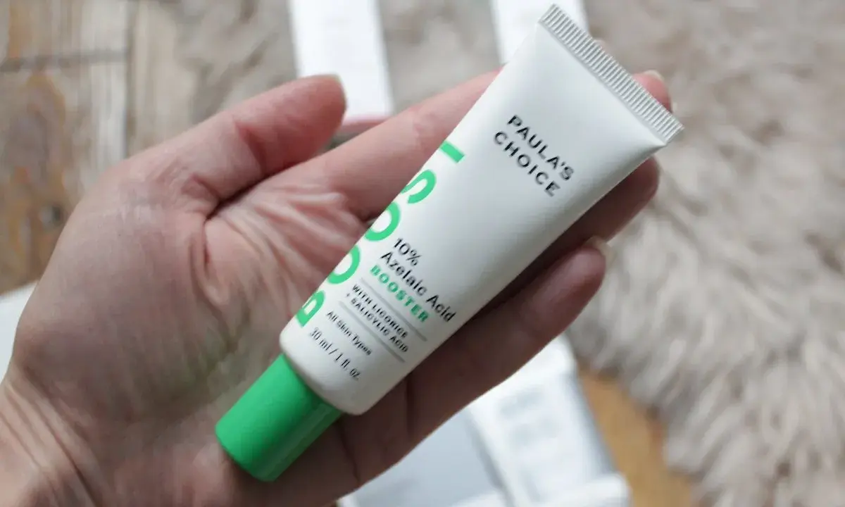 Tube de Paula's Choice 10% Azelaic Acid Booster, contenant de l'acide azélaïque et de la vitamine C, tenu dans une main.