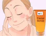 Une jeune femme applique un gommage facial pour savoir comment enlever les boutons sur le visage en une nuit.