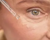 Goutte de sérum sur la peau, près de l'œil. Un soin à base de rétinol peut être utilisé après l'allaitement pour revitaliser la peau.