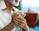 Homme âgé se tenant la main, cherchant un remède de grand-mère pour soigner crevasse doigt.