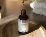 Goutte d'huile de nigelle purifiante tombant dans un flacon, idéale pour l'acné et les peaux à problèmes.
