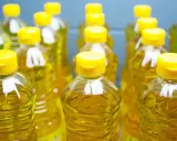 Plusieurs bouteilles d'huile de tournesol, au liquide doré, aux bouchons jaunes vifs. L'huile de tournesol, danger potentiel si mal stockée.