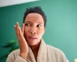Femme appliquant une crème contour des yeux pour atténuer ses cernes vasculaires.