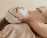 Visage couvert d'un masque blanc, une femme se détend. Attention à l'allantoïne, son danger potentiel pour la peau.