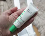 Tube de Paula's Choice 10% Azelaic Acid Booster, contenant de l'acide azélaïque et de la vitamine C, tenu dans une main.