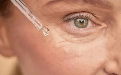 Goutte de sérum sur la peau, près de l'œil. Un soin à base de rétinol peut être utilisé après l'allaitement pour revitaliser la peau.