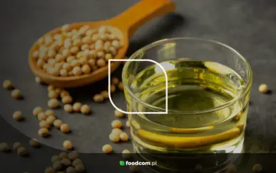 Grains de soja dans une cuillère en bois et un verre d'huile de soja, illustrant les huile de soja bienfaits pour la santé.
