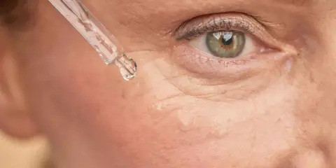 Goutte de sérum sur la peau, près de l'œil. Un soin à base de rétinol peut être utilisé après l'allaitement pour revitaliser la peau.