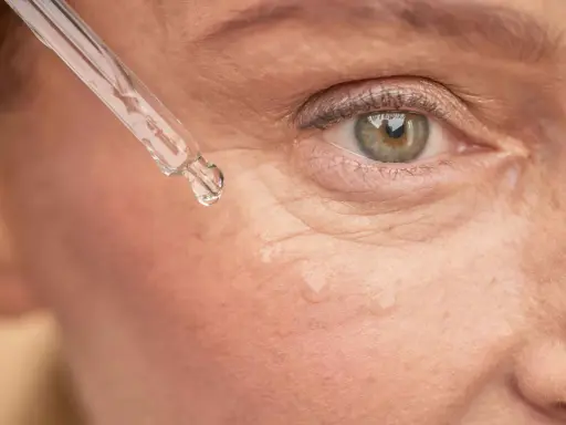 Goutte de sérum sur la peau, près de l'œil. Un soin à base de rétinol peut être utilisé après l'allaitement pour revitaliser la peau.