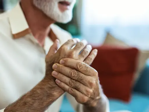 Homme âgé se tenant la main, cherchant un remède de grand-mère pour soigner crevasse doigt.