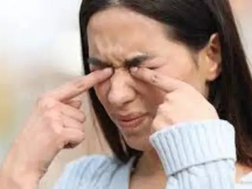 Une femme se frotte les yeux, une sensation de paupière qui gratte la dérange.