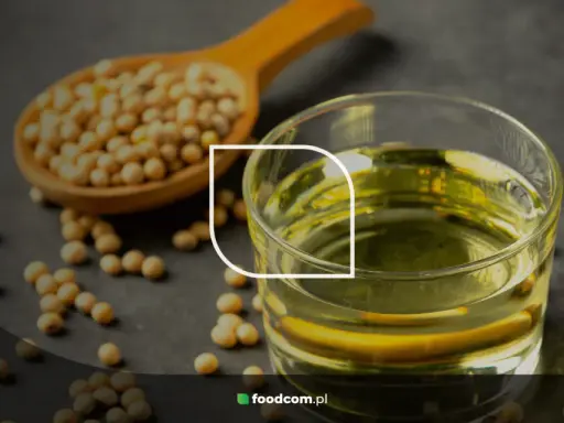 Grains de soja dans une cuillère en bois et un verre d'huile de soja, illustrant les huile de soja bienfaits pour la santé.