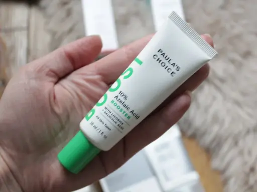 Tube de Paula's Choice 10% Azelaic Acid Booster, contenant de l'acide azélaïque et de la vitamine C, tenu dans une main.
