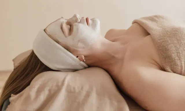 Visage couvert d'un masque blanc, une femme se détend. Attention à l'allantoïne, son danger potentiel pour la peau.