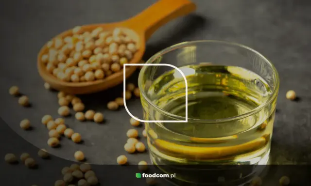 Grains de soja dans une cuillère en bois et un verre d'huile de soja, illustrant les huile de soja bienfaits pour la santé.