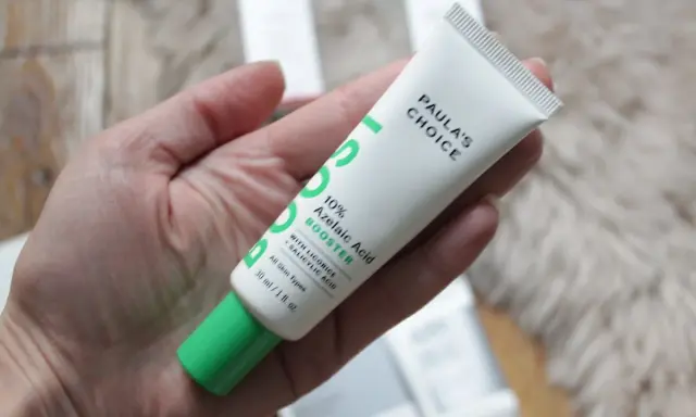Tube de Paula's Choice 10% Azelaic Acid Booster, contenant de l'acide azélaïque et de la vitamine C, tenu dans une main.