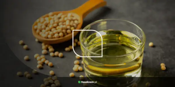 Grains de soja dans une cuillère en bois et un verre d'huile de soja, illustrant les huile de soja bienfaits pour la santé.